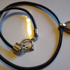 Black leather necklace with silver pendant.